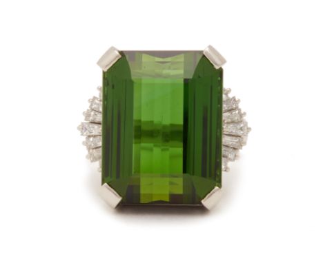 A TOURMALINE AND DIAMOND RING
Set in platinum, the step cut tourmaline flanked by tapered baguette cut and round brilliant cu