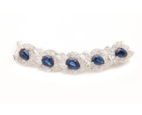 A BLUE SAPPHIRE AND DIAMOND BROOCH
Set in 20k white gold, the pear shaped sapphires each with a surround of diamonds in the f