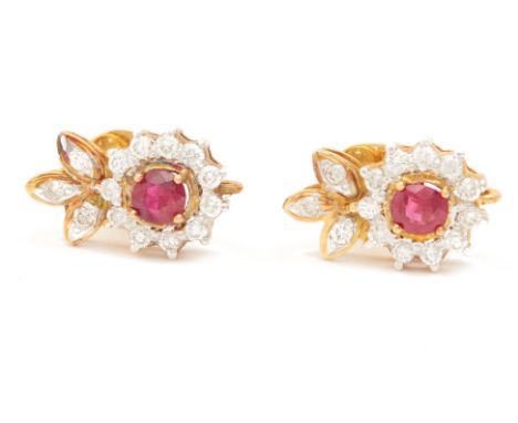A PAIR OF RUBY AND DIAMOND CLUSTER EARRINGS
The oval cut ruby within a border of round brilliant cut diamonds, two colour gol