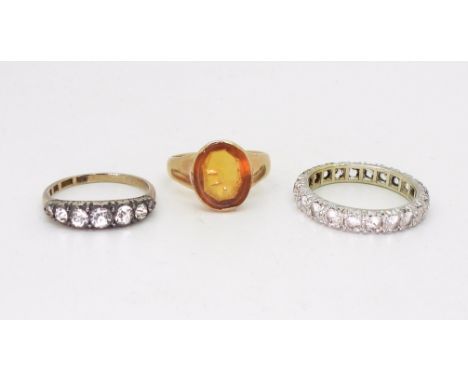 A clear gem set eternity ring, set with clear gems, size S1/2, a 9ct gold five stone clear gem set ring, size N, a yellow met