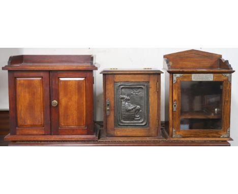 A lot of three assorted smokers cabinets, one with pewter relief depicting a reclining man smoking a pipe (3) Condition Repor