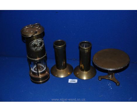 A brass Miner's lamp plus two brass candle holders and brass drop down trivet.