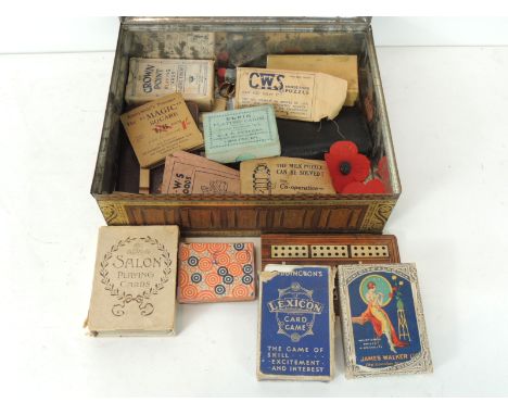 A Peak Frean biscuit tin containing early 20th Century packs of playing cards, magic tricks & games etc