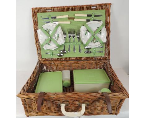 A Brexton woven cane picnic hamper complete with contents including ceramic plates, cups & saucers, plastic containers & cutl