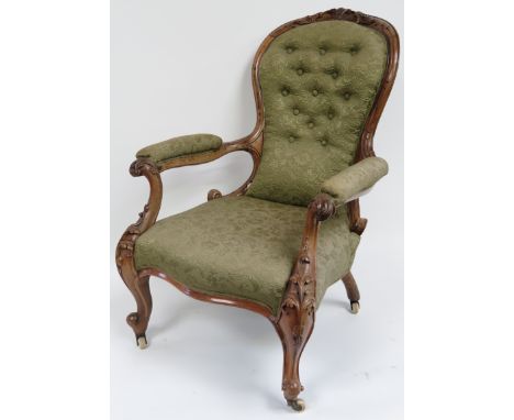 A Victorian walnut framed upholstered open armchair with foliate carved back & arm supports, in light green brocade