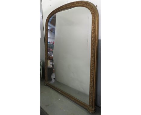 A Victorian arched gilt gesso overmantel mirror on original white ceramic ball supports, 165cm x 138cm