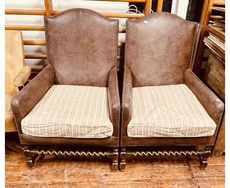 A pair of 20th century leather and brass studded armchairs, in a George III manner, arch back rest, box shaped armrests, foam