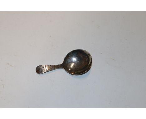 A Georgian silver caddy spoon with engraved Fleur de Lys and a shield handle, London 1794