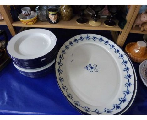 Two large oval enamel serving dishes together with a selection of white enamel plates