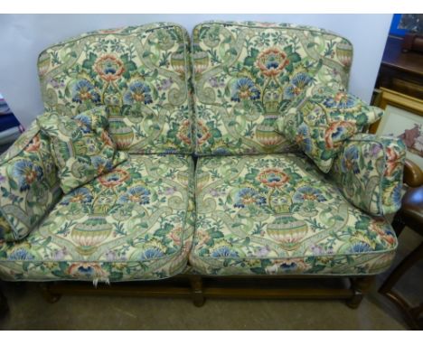A Vintage Light Teak Ercol 3-seater Sofa, the sofa having carved ecclesiastical back with William Morris design fabric, on tu