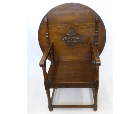 An Oak Circular Monks Bench/Table, with decorative carving to front panels, supported on turned legs with straight stretchers