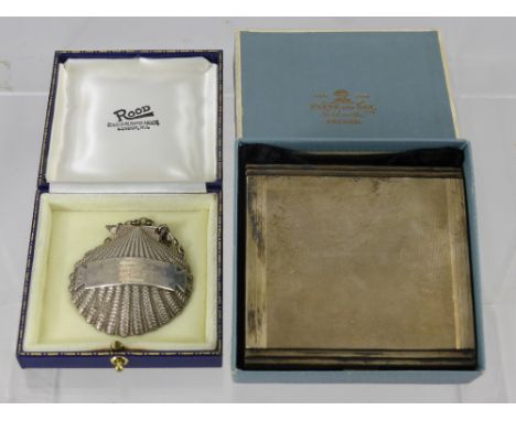 A Silver Cigarette Case, engine turned, Birmingham hallmark, dated 1954, mm D. Bros together with a silver bottle label, Lond