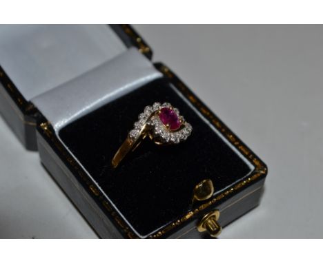 A 14ct gold ruby and diamond set cross over ring