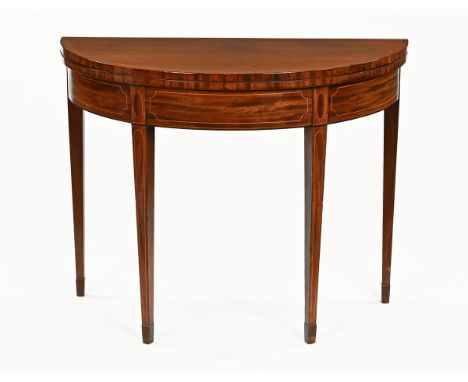 A George III mahogany turnover top tea table, with glass protective top recessed frieze and raised on tapered legs of square 