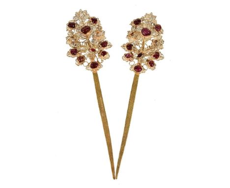 A pair of Chinese white metal and ruby hair ornaments, each with filigree 'flower and bird' finials inlaid with rubies, tests