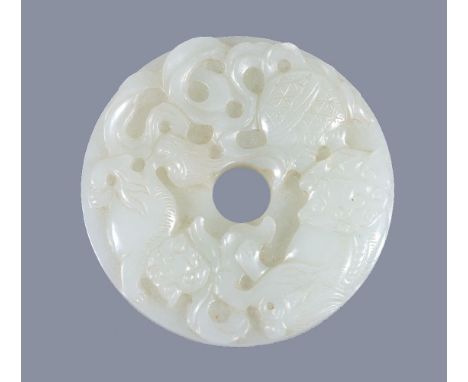 A Chinese white jade 'Buddhist Lion' disc, bi, of even pale tone, carved with two lions chasing a brocade ball, the reverse c