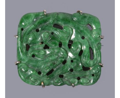 A Chinese green jadeite brooch, the openwork rectangular panel carved with a coiled dragon, jade plaque 3.6cm wide x 3.2cm hi