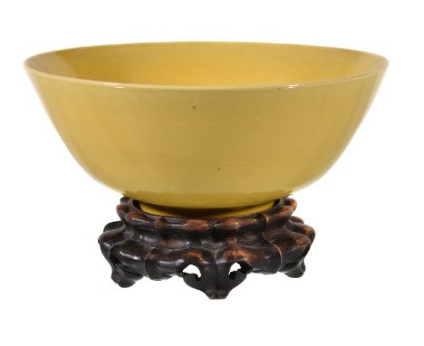 A Chinese yellow-glazed bowl, with deep rounded sides rising from a very short foot ring to a straight rim, covered in a fine