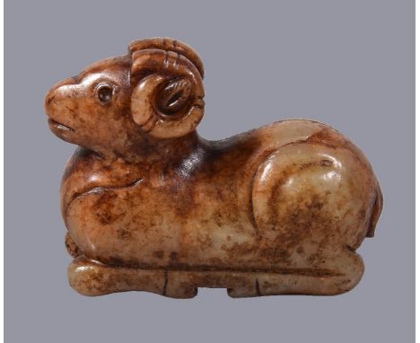 A Chinese celadon and russet jade figure of a ram, recumbent, with head looking forwards and its long horns curled behind its