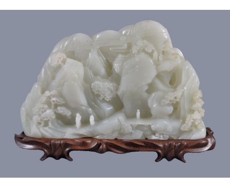 A large white jade 'landscape' boulder carving, of irregular shape, carved on one side in varying depths of relief with schol