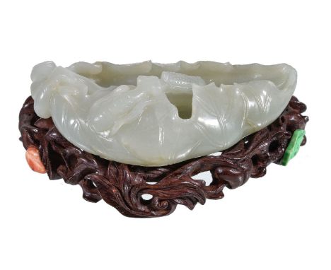 A Chinese white jade brush washer, with minor russet inclusions, carved in the form of a lotus leaf, the interior with two cr