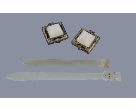 Two Chinese pale celadon jade hair pins, each of thin, curving section and spatulate form surmounted by a reticulated finial,