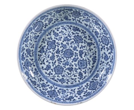 A Chinese blue and white 'Floral Scroll' Dish, Qing Dynasty, Yongzheng, in Ming-style, sturdily-potted with rounded sides and