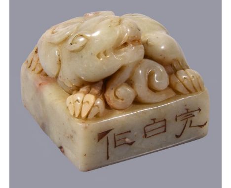 A Chinese 'Mythical Beast' square jade or hardstone seal, possibly 18th or 19th century, the pale coloured stone with mottled