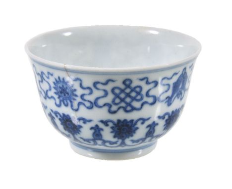 A Chinese blue and white small bowl, the steep sides with the bajixiang above stylized lotus sprays and leaf-shaped lappets e