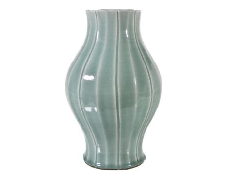 A fine Chinese celadon-glazed vase, Qing Dynasty, Qianlong mark and period, the baluster body moulded with vertical ribs, ris