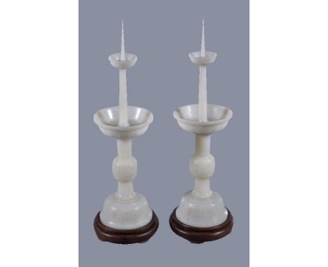 A pair of Chinese white jade candlesticks, each well carved in the form of a tapering cylinder with central knop carved with 