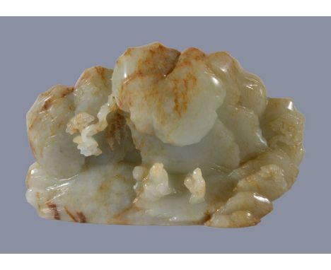 A Chinese celadon and russet jade boulder carving, one side with a sage and attendant beneath rocks with pine trees carved on