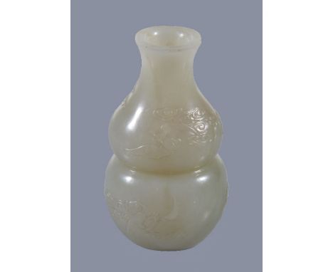 A small Chinese white or pale celadon jade 'bat and cloud' vase, of double-gourd form carved with bats and clouds with white 