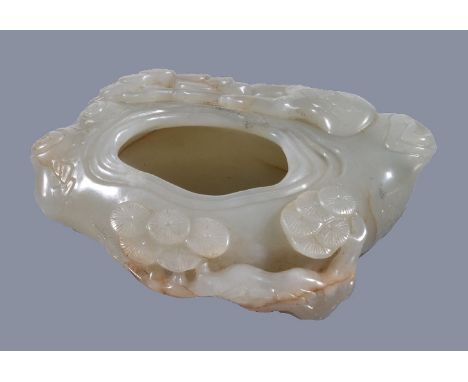 A Chinese white or pale celadon and russet jade 'pine tree' brush washer, well carved with pine branches, the base with brown