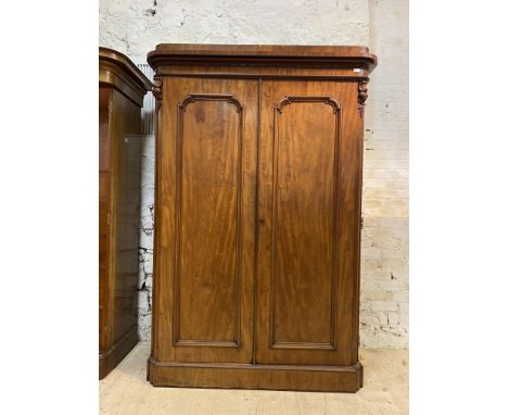 A Victorian mahogany wardrobe, the caddy top over scroll carved frieze and twin panelled doors enclosing silk lined interior 