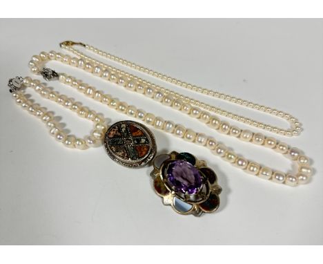 A Scottish sterling silver hard stone mounted oval shaped brooch with faceted amethyst centre, (5cm x 4cm) and a white metal 