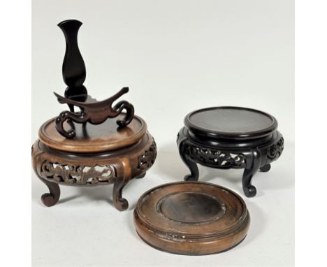 A Chinese hardwood plate stand, (h 13cm x 7cm x 10cm) a hardwood vase stand with pierced border raised on four scroll feet, (