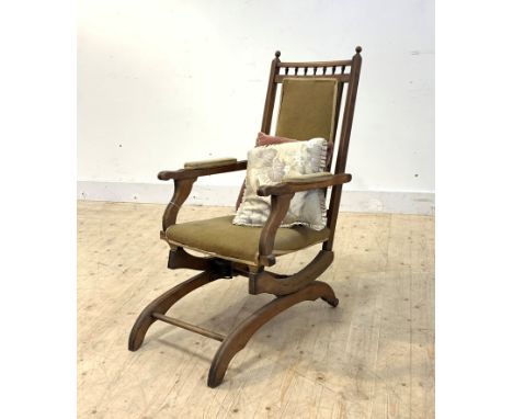 A late 19th/ early 20th century upholstered mahogany framed American rocker, on rear ceramic castors, H103cm