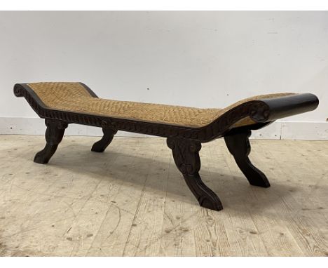 A carved hardwood scroll end window bench of Regency design wiyth overstuffed split cane covered seat, H46cm, L172cm, D47cm