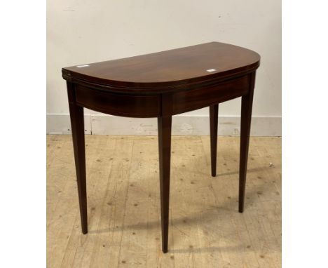 A Georgian inlaid mahogany demi lune fold over card table with baize lined playing surface, raised on square tapered supports