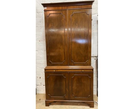 A Georgian style mahogany bookcase cabinet, the twin panelled doors enclosing three adjustable shelves, over brushing slide a