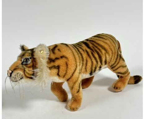 A German Steiff plush mohair tiger with inset glass eyes and stud to ear, (h 19cm, excluding tail 39cm, 11cm)