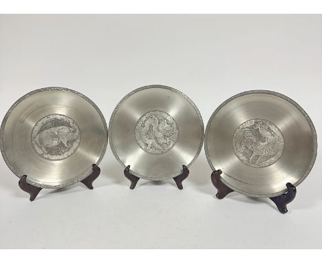 A set of three Chinese zodiac pewter plates dated 1981, 1986 and 1988, The Year of the Pig, The Year of the Dragon and the Ye