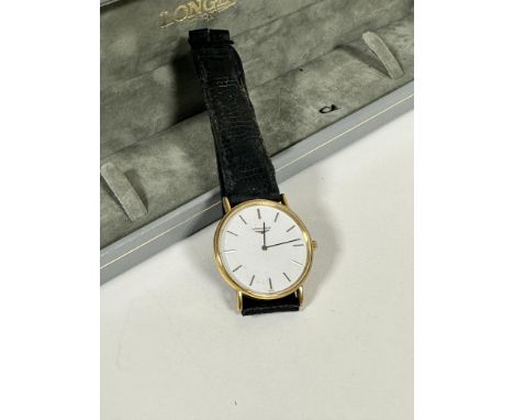 A gentleman's Longines water-resistant yellow metal quartz wristwatch with circular enamel dial and baton hour markers, on bl