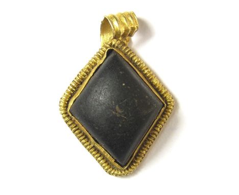Anglo-Saxon PendantCirca 6th century AD. Gold, 2.14 grams. 21.04 x 14.68 mm. A lozenge-shape pendant set with a large dark re