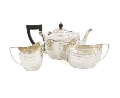 A three-piece silver tea set,by The Barker Brothers, Chester 1911,panelled oval form, scroll handles, scroll handle and urn f