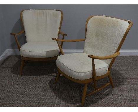 A pair of mid 20thC Ercol beech spindle back Easy Chairs, Model 477, the frame stamped 'Reg.Des 905.006', and one with hologr