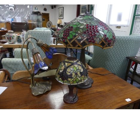 A Tiffany-style table lamp, with stained glass shade, 24in (61cm) high, together with two other Tiffany-style table lamps (3)