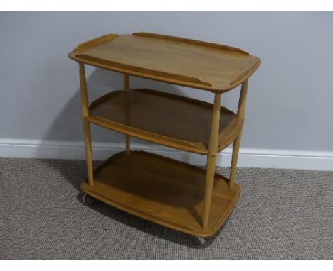 A mid 20thC Ercol three tier Trolley, Windsor 458, the rounded rectangular lipped elm shelves on tapering beech supports, all