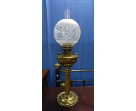 A Victorian style brass Oil Lamp, the brass reservoir with swirl fluted decoration, with funnel and frosted glass shade, 27in